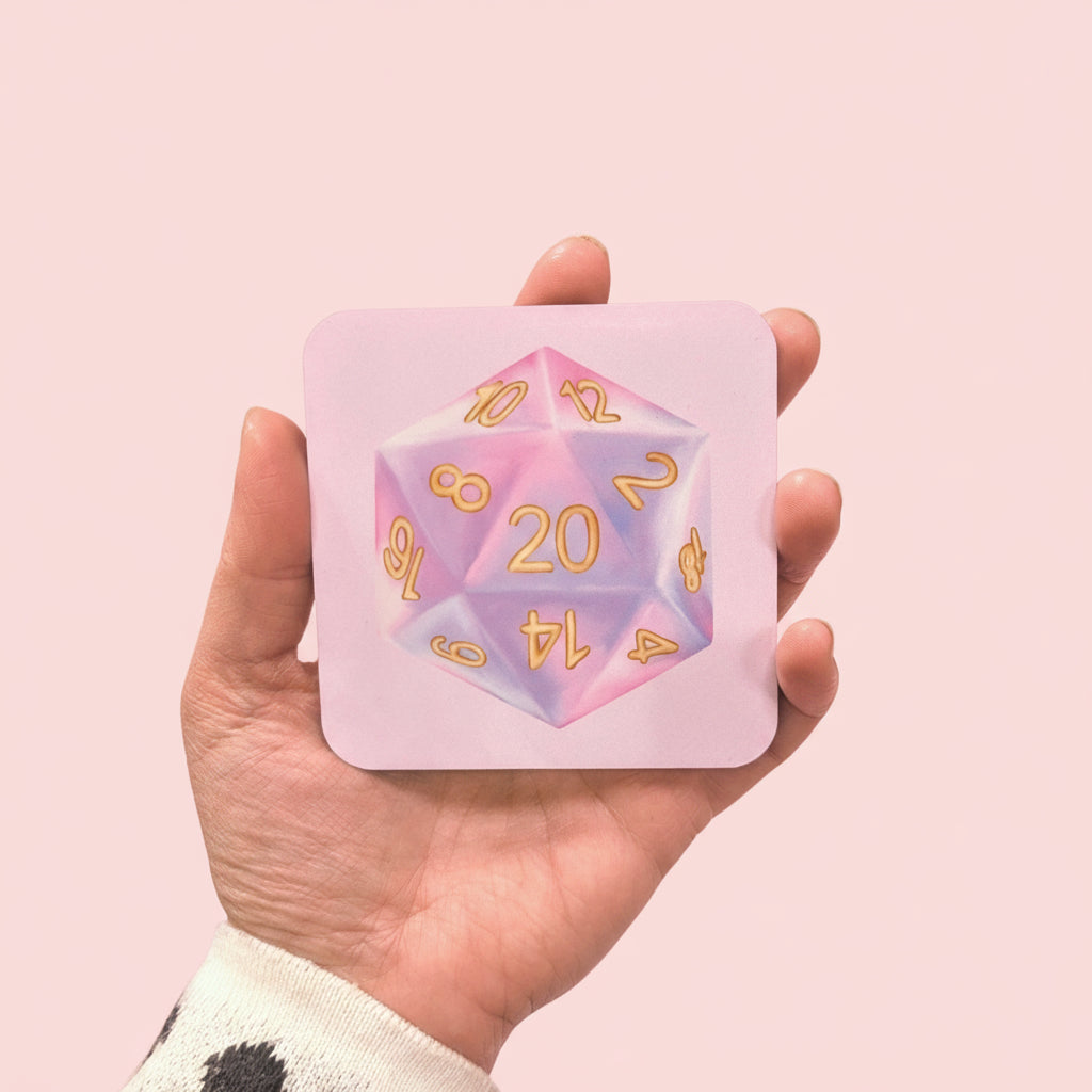 Hand holding a coaster with a pink and purple d20 dice illustration, against a light pink background