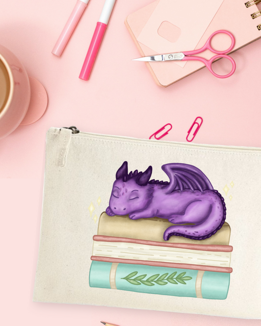Accessory Pouch with a printed illustration of a purple dragon asleep on a stack of books